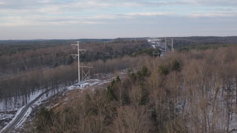 Aerial-View-of-Electrical-Power-Lines-in-Snowy-Forest-Landscape