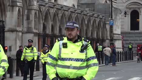 Primer-Plano-De-Un-Oficial-De-Policía-Reunido-Frente-A-Los-Tribunales-Reales-De-Justicia-En-Londres,-Reino-Unido.