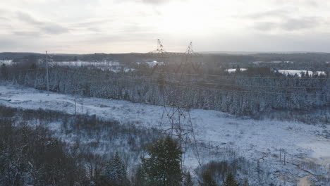 Electrical-Tower-in-a-Rural-Winter-Forest,-Aerial