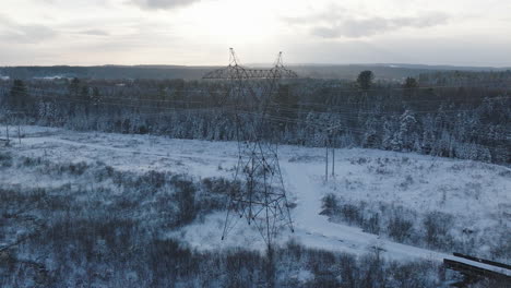 Torre-De-Energía-Eléctrica-En-Un-Bosque-Rural-De-Invierno,-Aérea