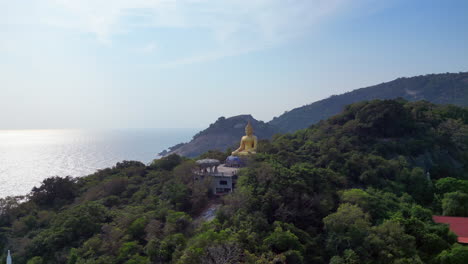 Un-Dron-Sigue-La-Estatua-Del-Buda-De-Oro-Tailandés-Bajo-El-Sol-De-La-Mañana