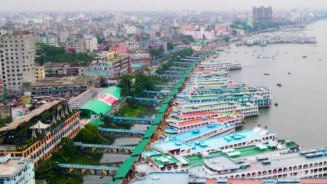Aerial-Toward-Ships-At-The-Largest-Sadarghat-Boat-Terminal-in-Buriganga-River,-Dhaka,-Bangladesh,---High-Angel-upward-pulling-shot