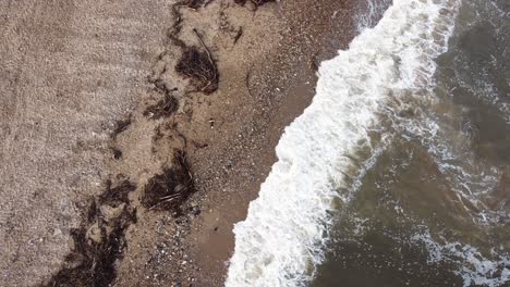 Kaltes-Nordseewasser-Strömt-An-Den-Mit-Algen-Bedeckten-Strand-In-England