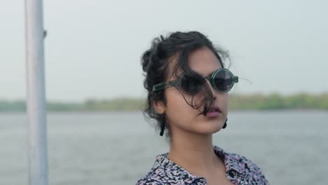 Close-up-shot-of-an-Indian-woman-with-sunglasses-looking-Away-and-then-turns-towards-the-camera