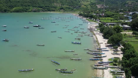 Clear-water-and-multiple-boats-on-the-coast-of-Lombok,-Indonesia-on-a-hot-summers-afternoon