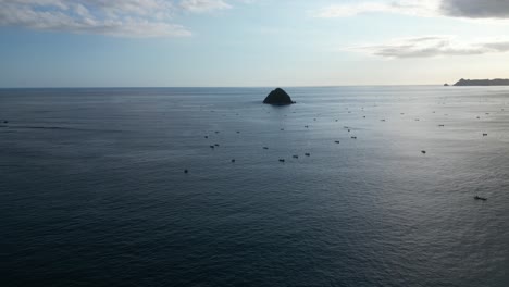 Una-Pequeña-Isla-Aislada-En-El-Mar-Y-Rodeada-De-Barcos-Frente-A-La-Costa-De-Lombok,-Indonesia