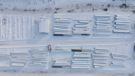 Snow-Covered-Construction-Supply-Yard-in-the-Winter,-Aerial-Top-Down