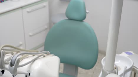 Vista-Cenital-De-La-Silla-De-Un-Dentista-Azul-En-Una-Clínica-Dental-Vacía-Con-El-Equipo-Necesario-Listo-Para-Tratar-Problemas-Dentales