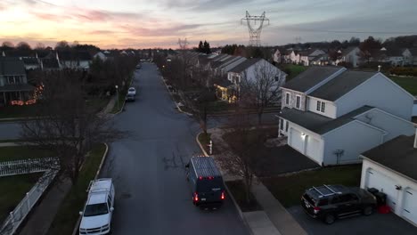 Amazon-delivery-van-driving-in-American-neighborhood-during-winter-sunset