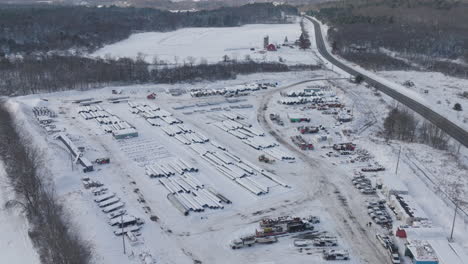 Snow-Covered-Outdoor-Industrial-Materials-Supply-Yard-in-the-Winter,-Aerial