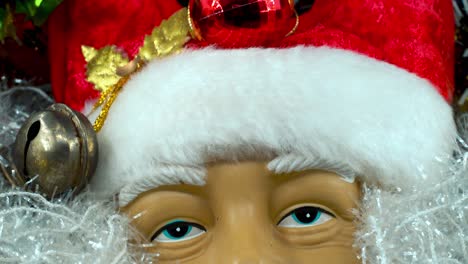 Happy-Santa-Claus-toy-in-a-red-hat-with-bells,-big-white-beard,-Christmas-decoration,-traditional-holiday-presents,-new-year-decor,-shiny-colorful-decor,-Detailed-close-up-tilt-up-shot,-4K-video
