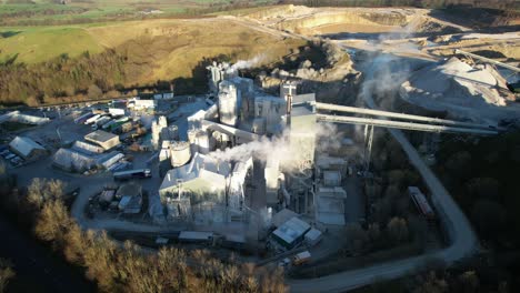 Large-industrial-quarry-with-smoke-from-chimneys,-in-England,-4K-Aerial-footage