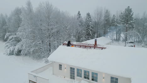 Male-Carpenter-or-sweeper-working-on-roof-in-harsh-winter-conditions
