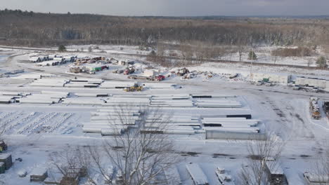 Construction-Materials-Supply-Yard-Covered-in-Snow,-Aerial
