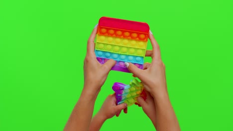 Hands-of-woman-and-kid-play-trendy-push-pop-it-bubble-fidget-anti-stress-toys-game-on-chroma-key