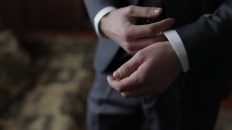 Handsome-groom-fixes-his-cuffs-on-a-jacket.-Wedding-morning.-Businessman