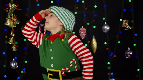 Kid-girl-in-Christmas-elf-Santa-helper-costume-getting,-receiving-present-gift-box.-New-Year-holiday