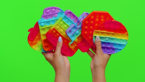 Female-hands-with-push-pop-it-bubble-fidget-stress-anxiety-relief-squeeze-sensory-toys-on-chroma-key