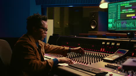 Portrait-of-african-american-sound-designer-mixing-and-mastering-tracks