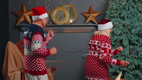 Fröhliches-älteres-Großelternpaar-Tanzt-Zu-Hause-In-Der-Nähe-Des-Weihnachtsbaums-Und-Feiert-Das-Neue-Jahr