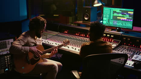 Rockstar-recording-music-on-his-guitar-in-professional-studio