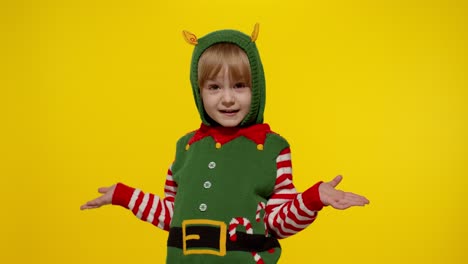 Schockiertes-Mädchen-Im-Weihnachtselfen-Kostüm-Als-Weihnachtsmann-Helfer.-Kind-Schaut-In-Die-Kamera-Und-Stellt-Die-Frage-„Was?“