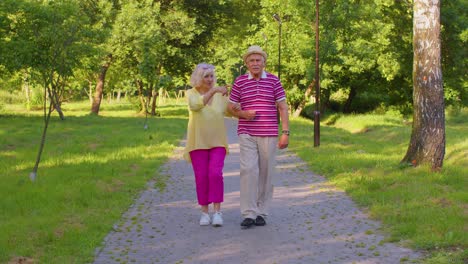 Pareja-De-Jubilados-Con-Estilo-Senior-Abuela-Abuelo-Caminando,-Disfrutando-Del-Tiempo-Juntos-En-El-Parque
