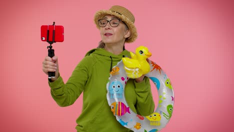 Mature-grandmother-traveler-blogger-in-sunglasses,-taking-selfie-on-mobile-phone,-video-call-online