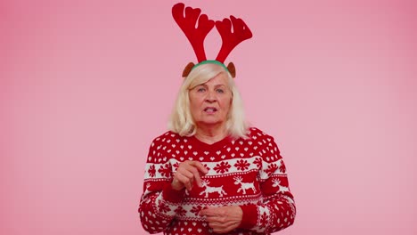 Angry-old-woman-in-Christmas-deer-antlers-raising-hands-in-indignant-expression-quarreling-conflict