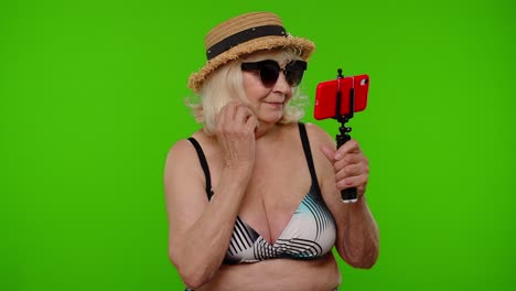 Mature-woman-traveler-blogger-in-sunglasses,-taking-selfie-portrait-photo,-video-call-on-smartphone