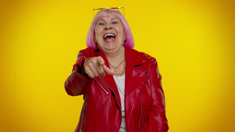Elderly-amused-woman-pointing-finger-to-camera-laughing-out-loud-of-ridiculous-appearance-funny-joke