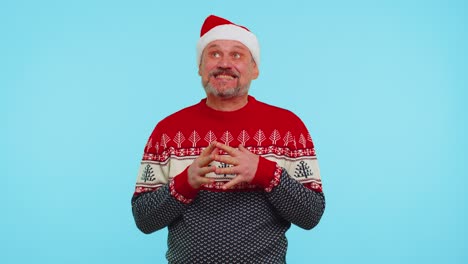 Cheerful-man-in-sweater-Santa-Christmas-hat-getting-present-gift-box,-expressing-amazement-happiness