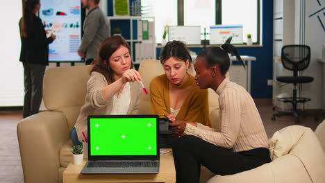 Businesswomen-discussing-in-back-of-laptop-with-greenscreen