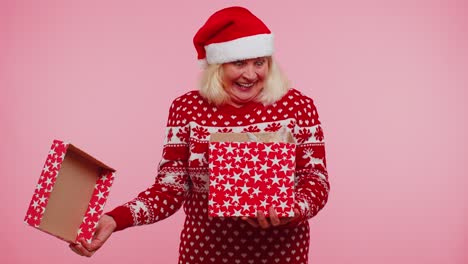 Großmutter-Im-Weihnachtspullover-Lächelt,-Packt-Geschenk-Aus,-öffnet-Schachtel-Mit-Hauskatze,-Tolle-Überraschung