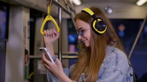 Young-woman-wearing-headphones-listening-music,-funny-relax-dancing-while-traveling-by-bus-to-city
