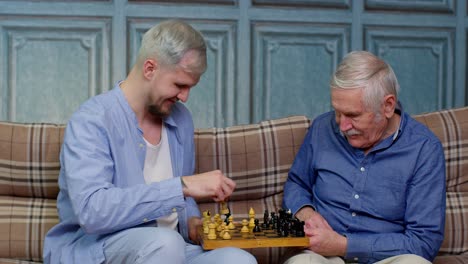 Happy-different-male-generations-family-of-senior-father-and-adult-son-or-grandson-playing-chess
