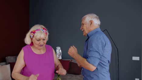 Glückliches-Altes-Seniorenpaar-Tanzt-Und-Hat-Spaß-Beim-Feiern-Des-Ruhestandsjubiläums-Im-Wohnzimmer-Zu-Hause