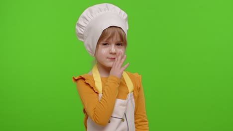 Child-girl-kid-dressed-as-cook-chef-holding-finger-on-her-lips-on-chroma-key,-gesture-hush,-secret