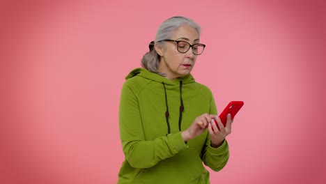 Ältere-Oma-Nutzt-Handy,-Um-Online-Zu-Surfen,-Sagt-„Wow,-Ja“,-Große-Gewinnnachrichten-Machen-Gewinnergeste