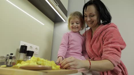 Cute-small-girl-cooking-with-her-mother.-Little-daughter-with-mother-together