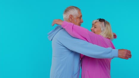 Romantic-senior-couple-grandfather-grandmother-hugging,-embracing,-looking-at-camera-and-smiling