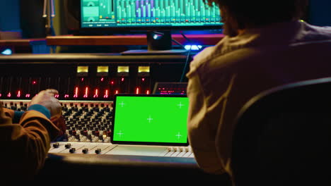 Artist-and-sound-designer-examine-digital-editing-software-and-mockup-on-tablet