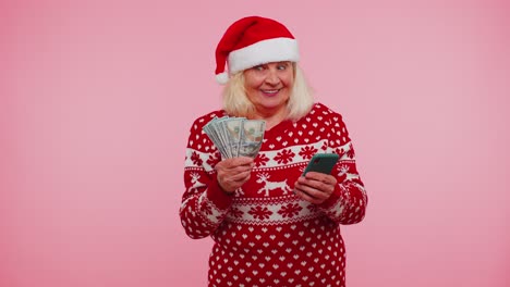 Navidad-Abuela-Mirando-Teléfono-Inteligente-Regocijándose-Sinceramente-Ganar-éxito-Suerte-Recibir-Dinero-En-Línea