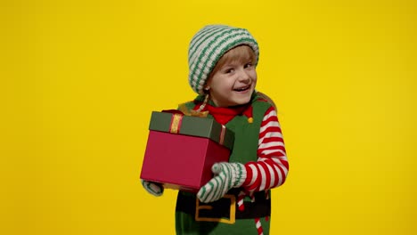Kleines-Mädchen-Im-Weihnachtselfenkostüm-Als-Weihnachtsmannhelfer-Erhält-Geschenkbox.-Frohe-Feiertage-Im-Neuen-Jahr