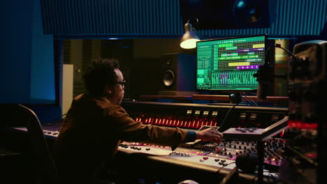 Sound-designer-uses-mixing-console-and-managing-audio-tracks