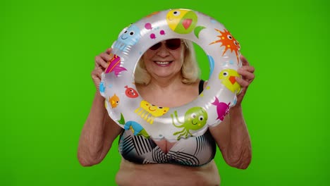 Senior-pensioner-woman-tourist-dancing,-celebrating,-smiling-with-rubber-swim-ring-on-chroma-key