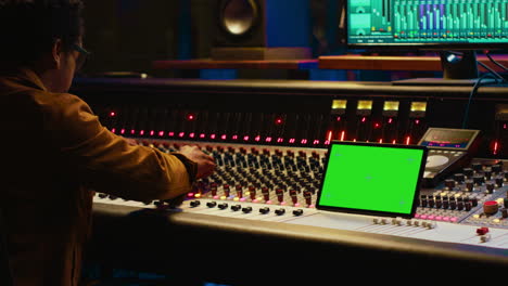 Professional-audio-technician-recording-tracks-with-mockup-on-tablet