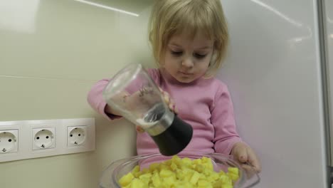 Kleines-Mädchen-Sitzt-In-Der-Küche-Und-Bereitet-Einen-Salat-Zu