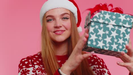 Chica-Alegre-Con-Suéter-Rojo-De-Navidad-Con-Ciervos-Presentando-Caja-De-Regalo-De-Navidad,-Venta-De-Compras-Navideñas