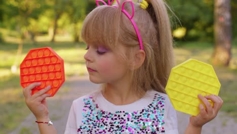 Girl-hiding-behind-two-pop-it-sensory-anti-stress-toys,-squishy-bubbles-trendy-game,-anti-stress